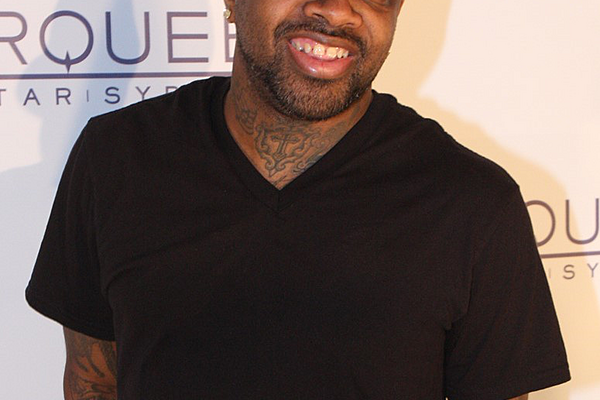 A man wearing a black t-shirt and a baseball cap.
