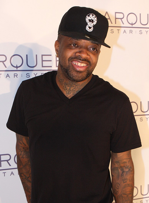 A man wearing a black t-shirt and a baseball cap.