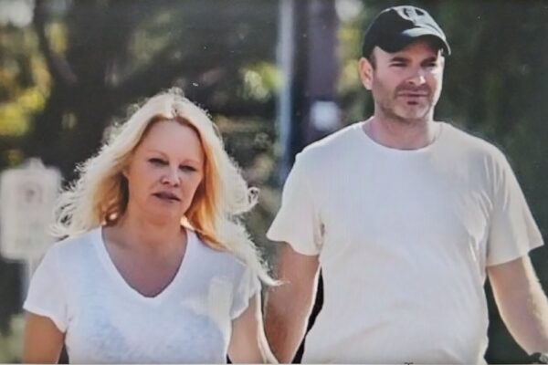A candid photo of Pamela Anderson walking with a man.