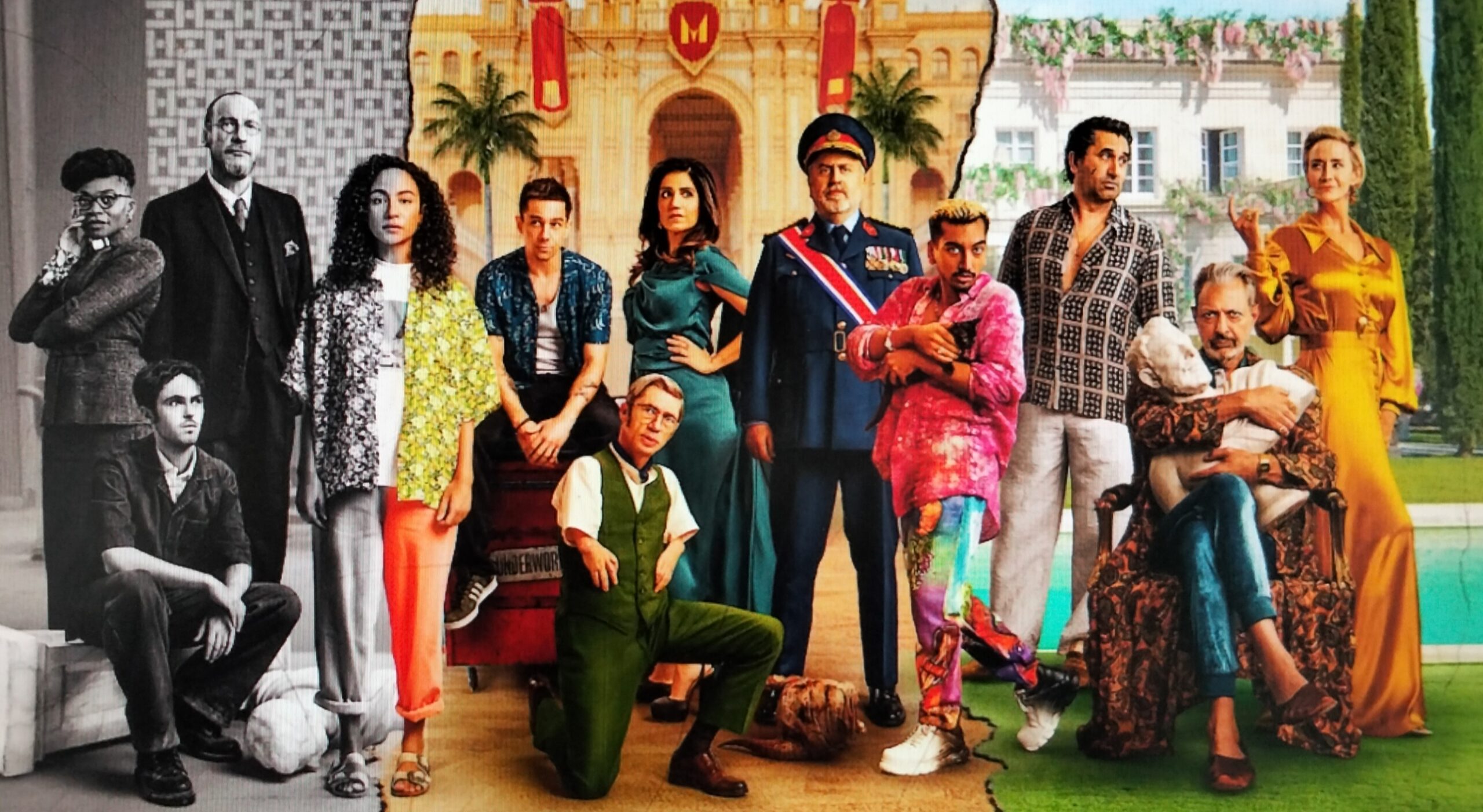 A group of actors in colorful costumes posing for a film poster.