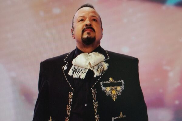A man in a traditional decorative black suit performing.
