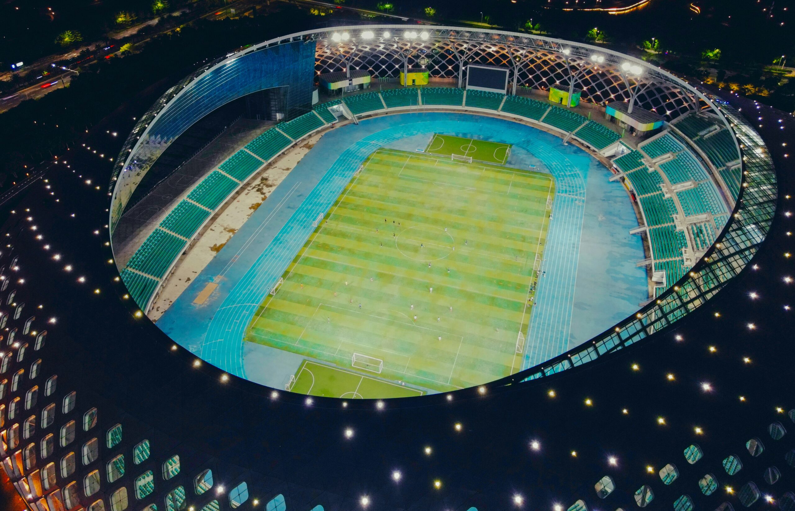 An overhead shot of a large, brightly lit sports stadium at night.
