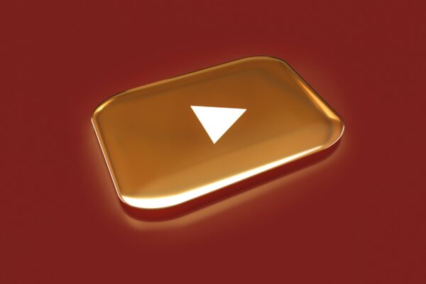 A gold YouTube play button icon on a dark red background.