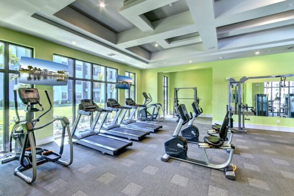 A bright, modern gym with treadmills and workout equipment.