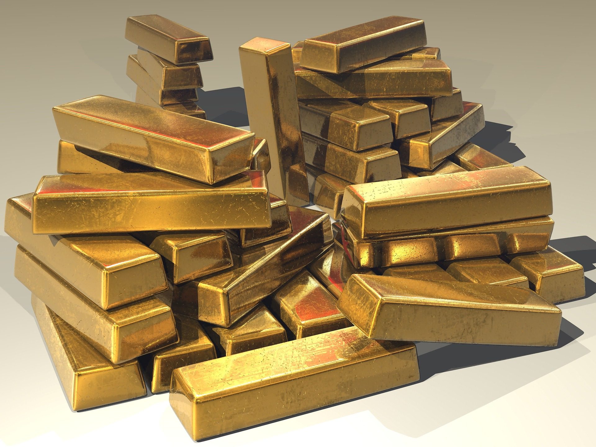 A large pile of shiny gold bullion bars stacked together.