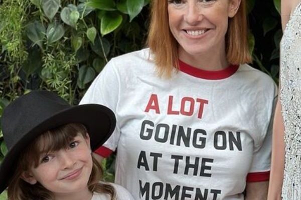 A woman in a white t-shirt posing with a young child.