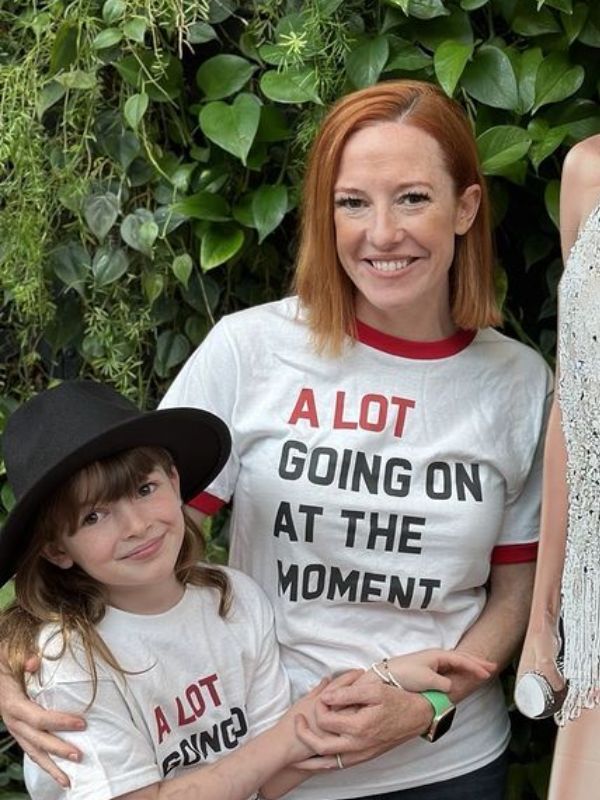 A woman in a white t-shirt posing with a young child.