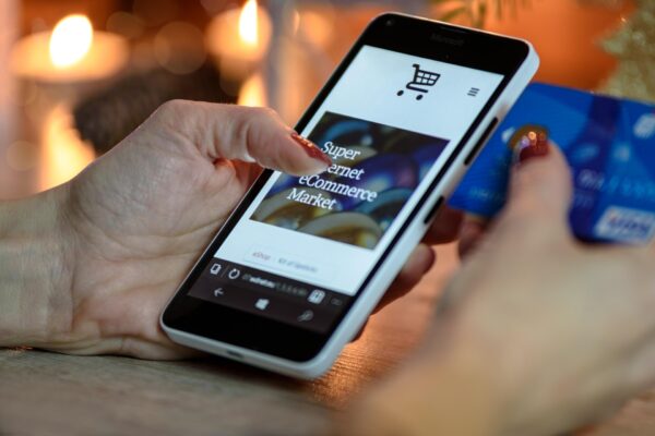 A person's hands using a smartphone to browse an e-commerce shopping app.