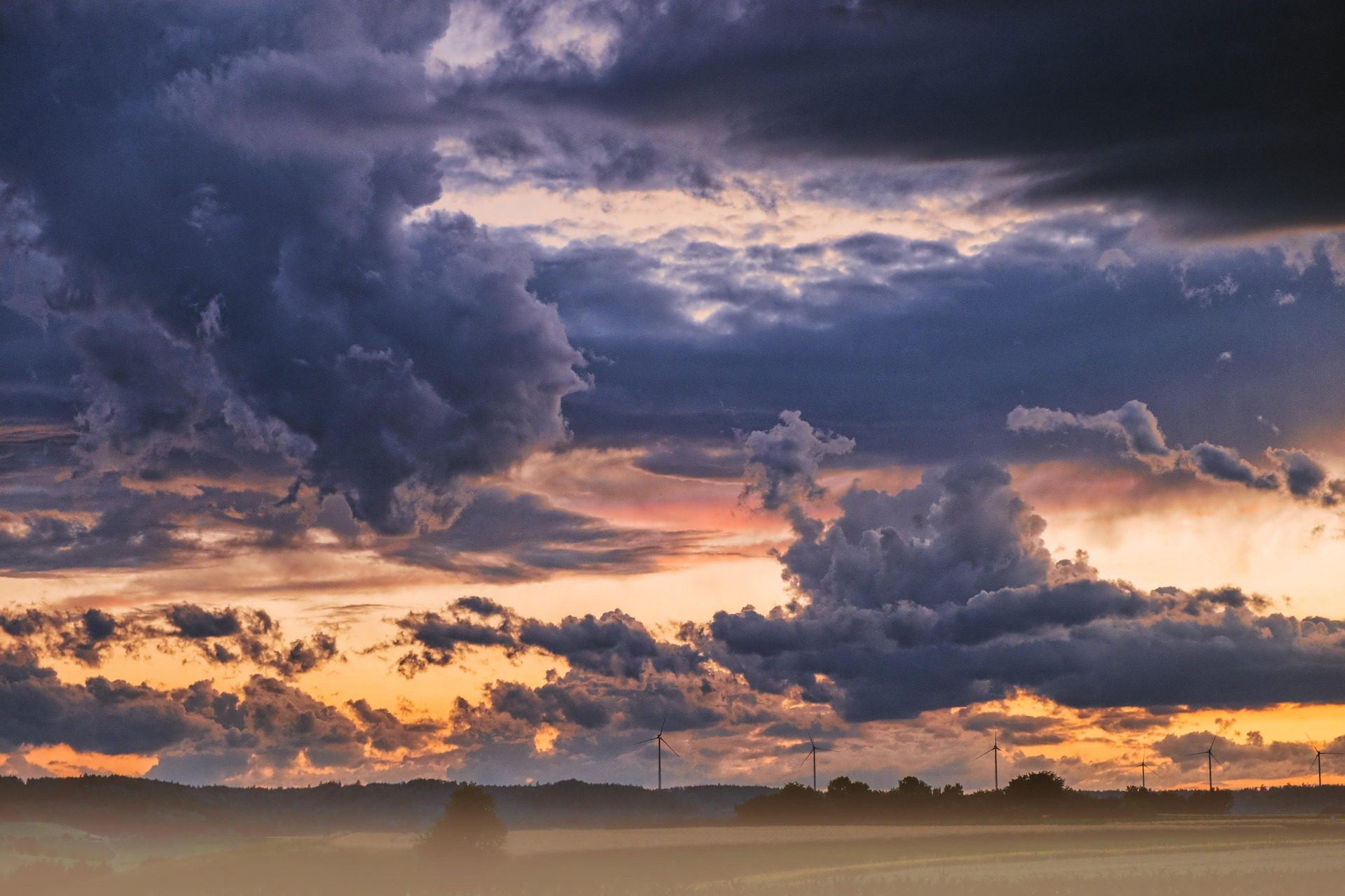 A dramatic sky with orange and blue clouds over a flat horizon.