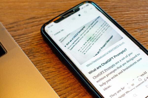 A hand holding a smartphone displaying a text-heavy article.