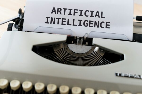 An old typewriter with a sheet of paper that says "Artificial Intelligence".