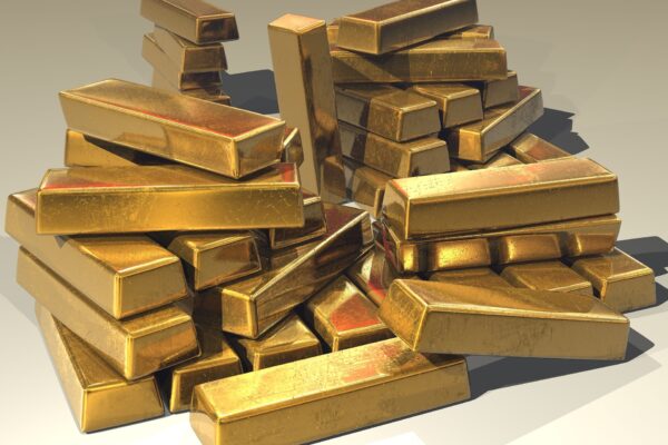 A large pile of shiny gold bullion bars stacked together.